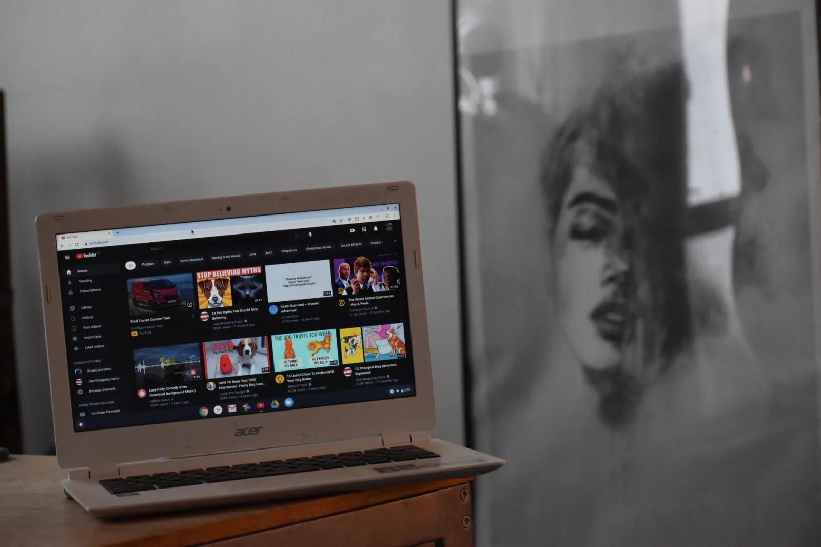 A laptop on a wooden table with a video page open on its screen