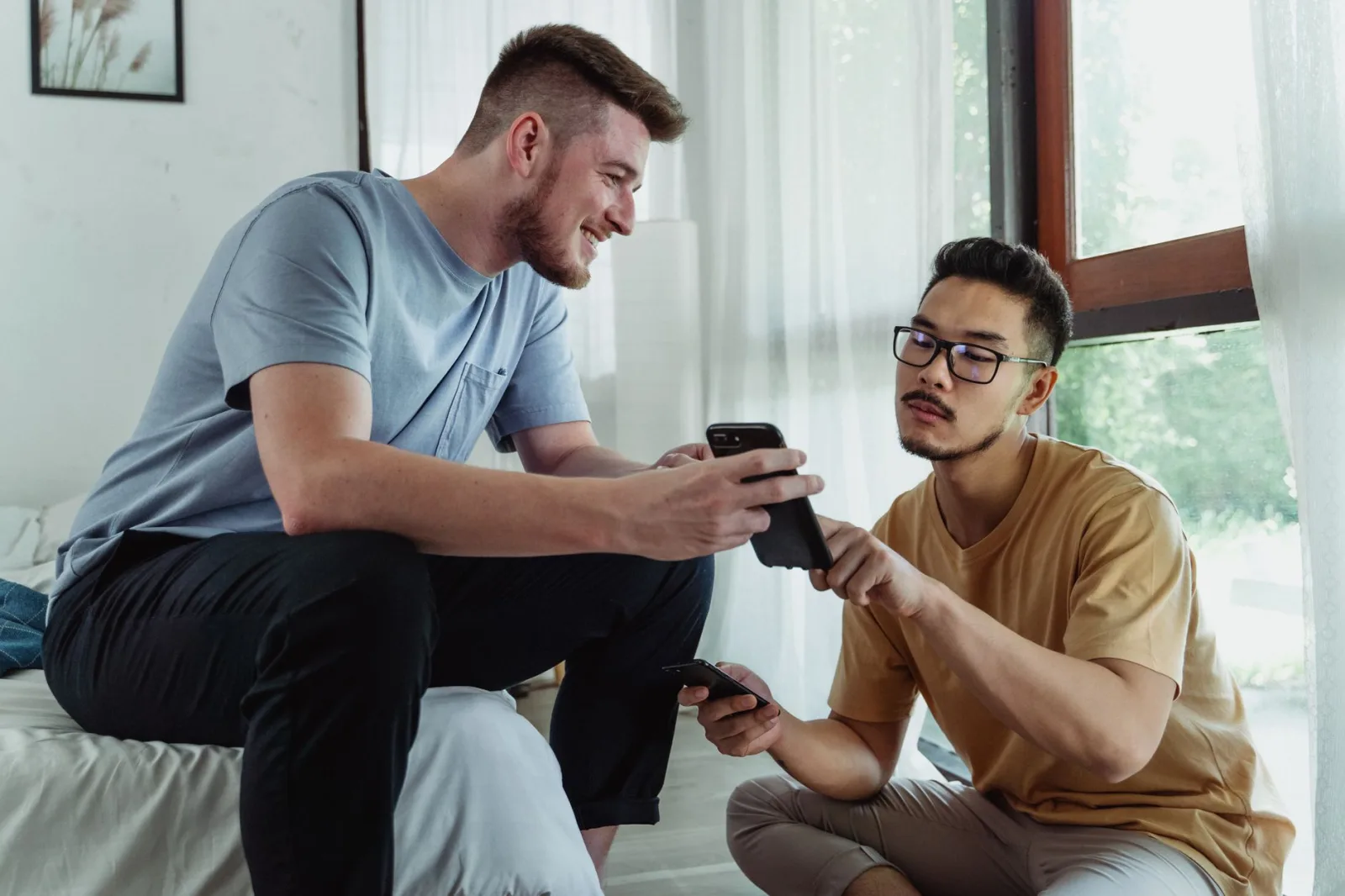Two people looking at a phone screen and discussing what is on it