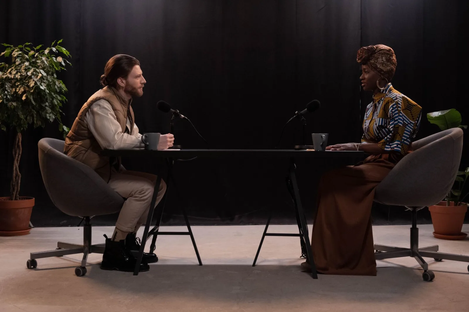 Two people in conversation in front of microphones during a recording session