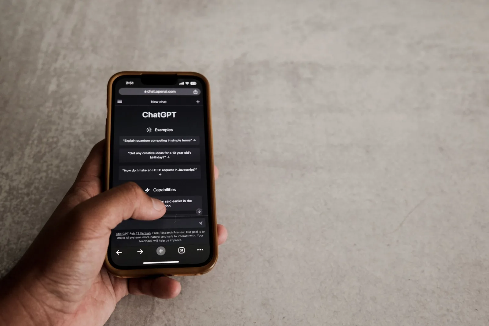 A phone in someone's hand showing a conversation with an AI assistant